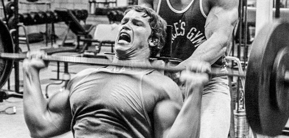 Seven time Mr. Olympia Arnold Schwarzenegger maximizing muscle growth while training with intensity.